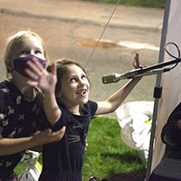Young girls sing into a microphone controlling lasers